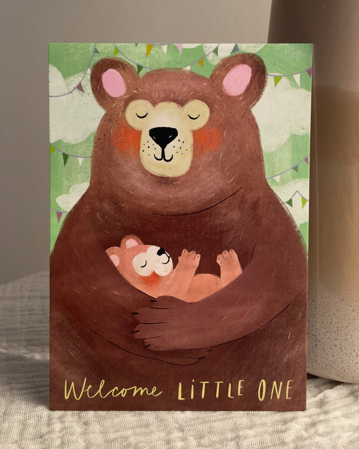 Postkarte "Welcome Little One" von Franzizo angelehnt an eine Vase auf einem Tisch